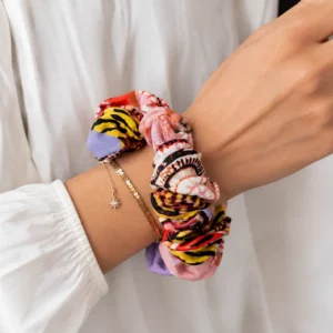 Chouchou patchwork de couleur porté au poignet d'une femme